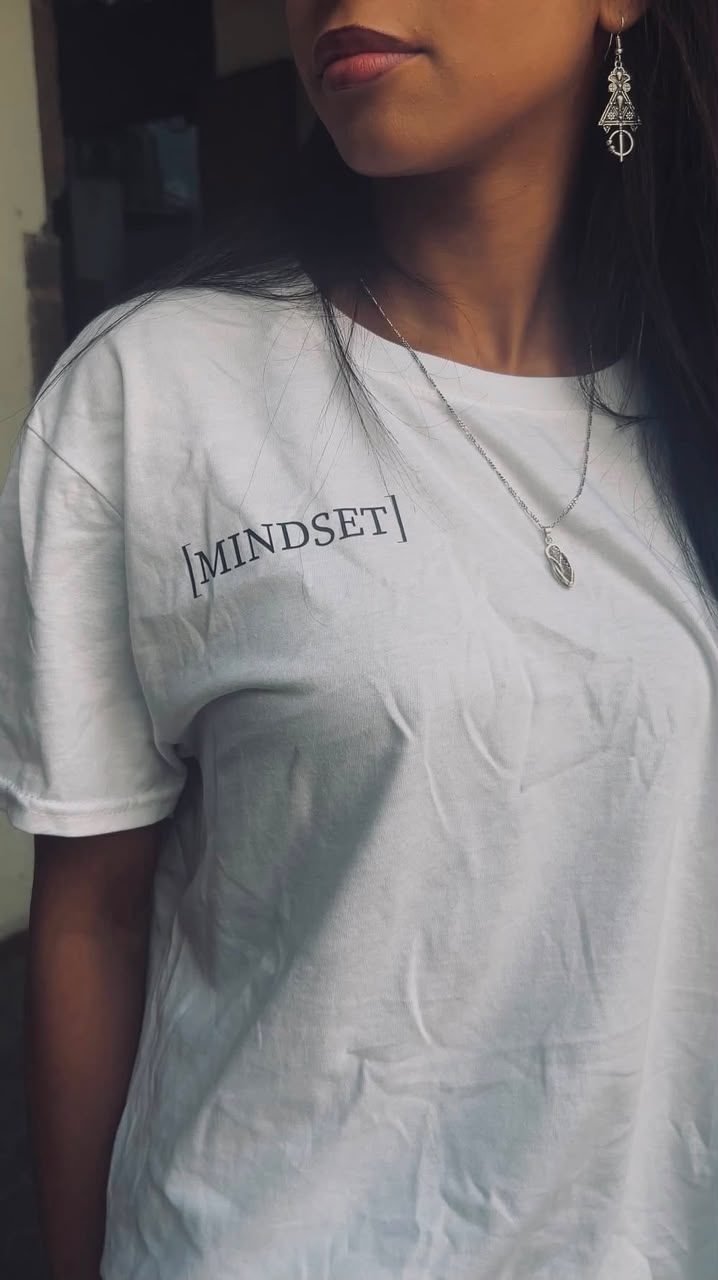 Gros plan sur le logo MINDSET imprimé sur la poitrine d'un t-shirt blanc.